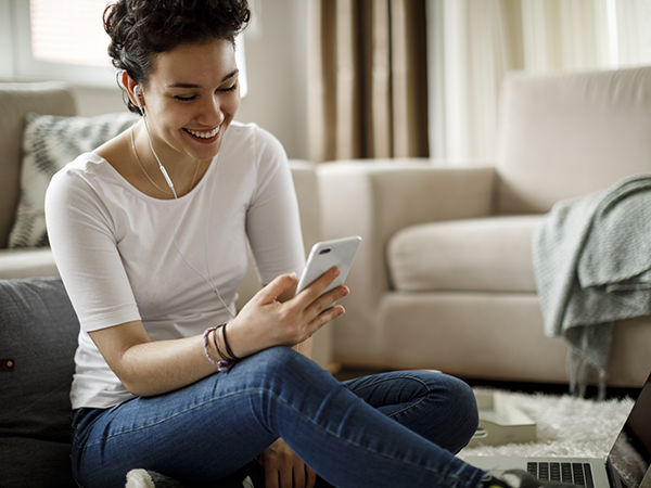 Woman looking at phone, sitting in living room