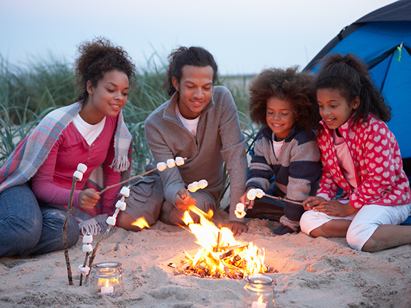 Family roasting marshmallows around a campfire