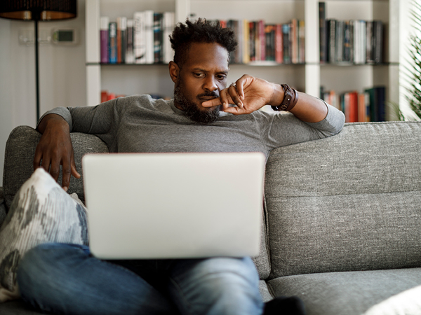 Man on laptop sitting on couch