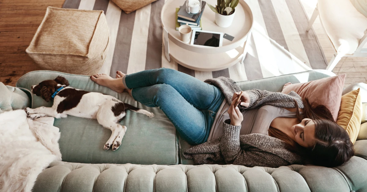 Women laying on couch with dog