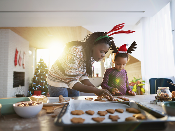 Woman and child decorating holiday cookies