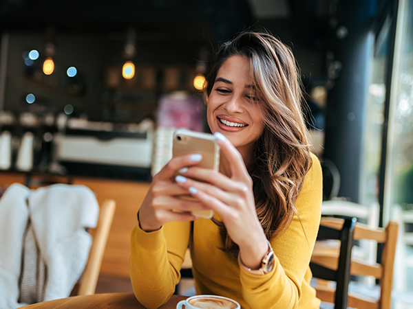Woman sitting in cafe looking at phone
