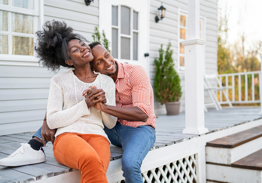 Black couple embracing on porch